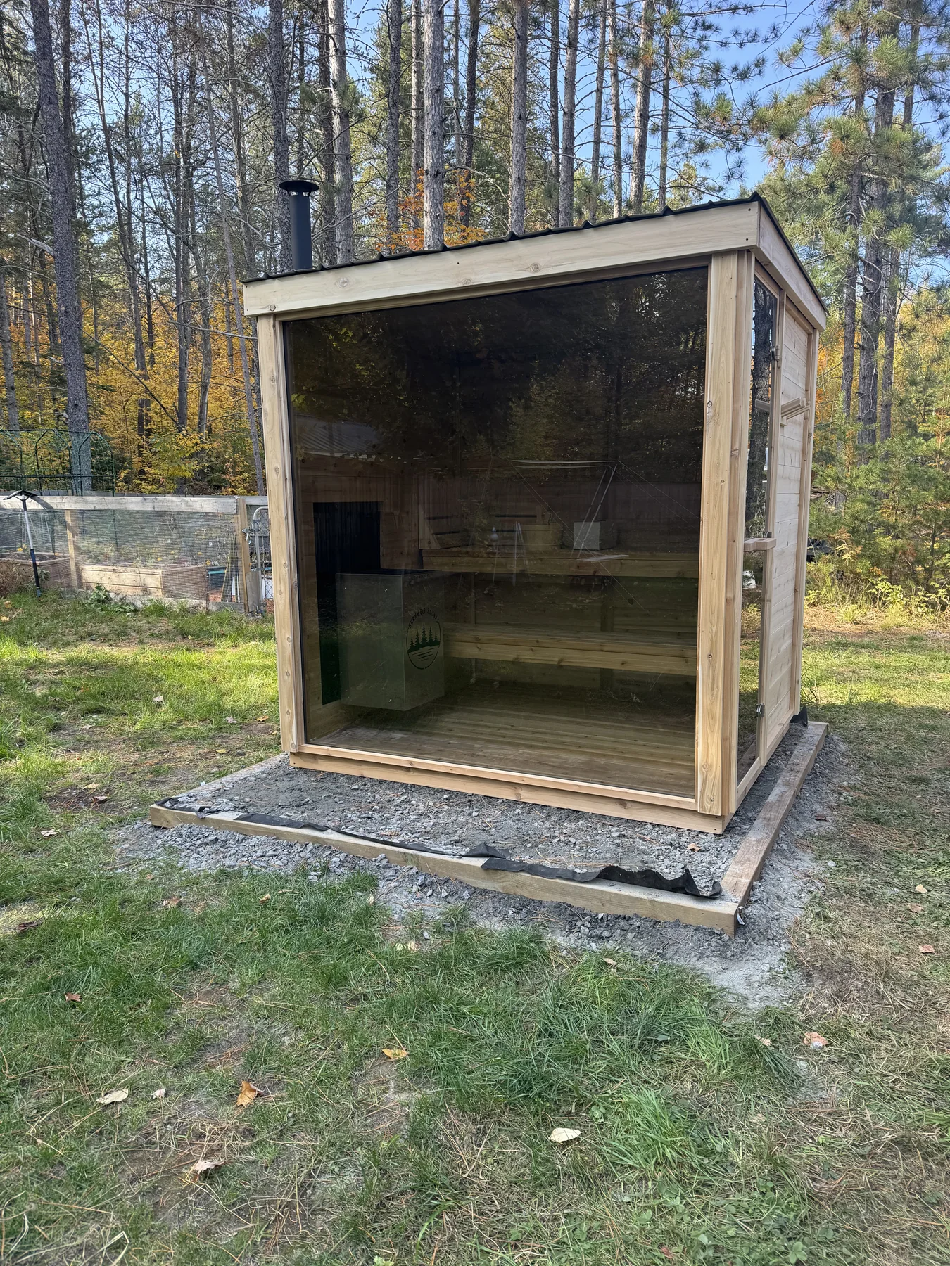 Completed Cube with full glass front among pines