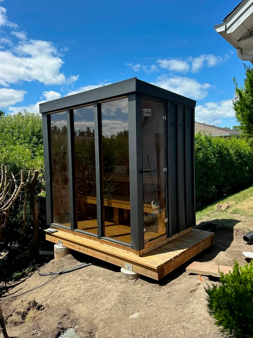 Installed Cube sauna with fitted black metal cladding viewed from the side
